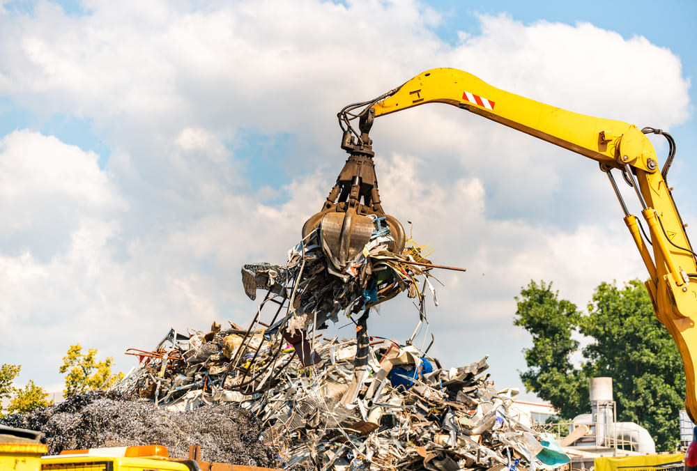 A crane lifting metal waste at a scrapyard