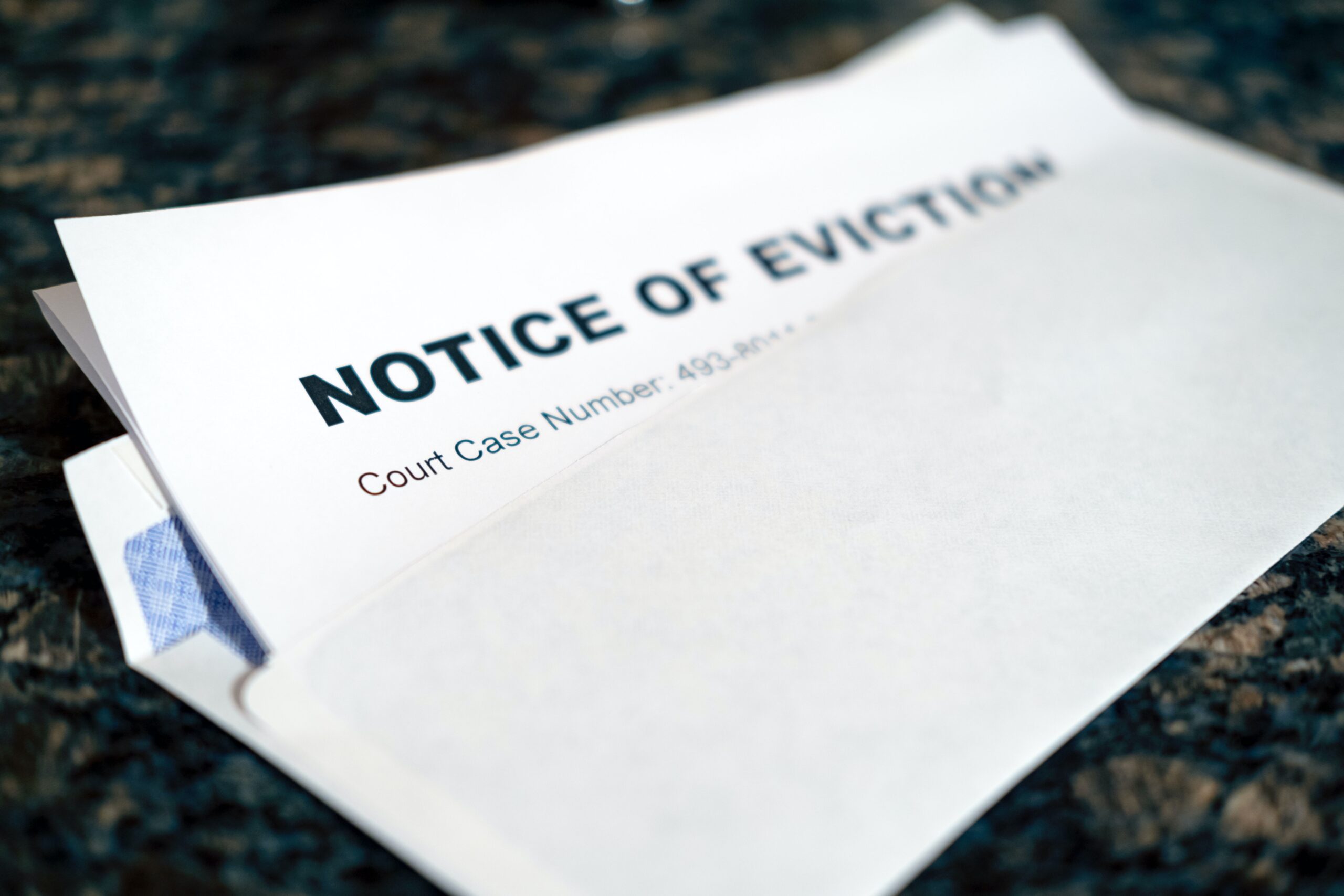 a white eviction notice paper with words written "Notice of Eviction"