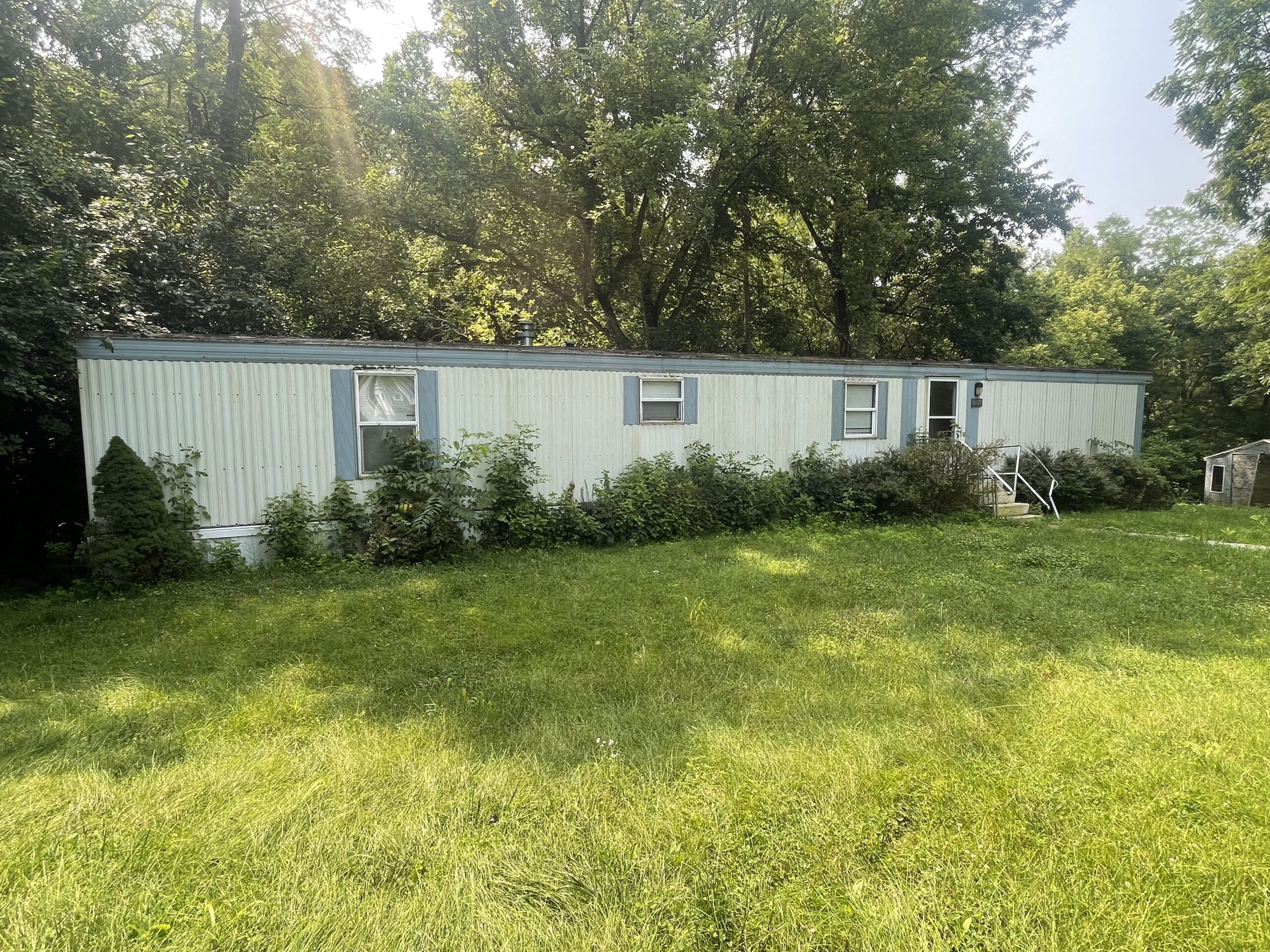 mobile home with bushes growing nearby