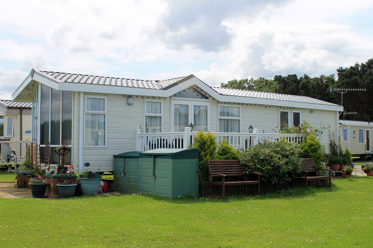 white mobile home with benches outside